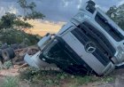 Caminhão com carga de madeira capota e fica com rodas para cima na RO-473