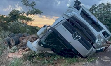 Caminhão com carga de madeira capota e fica com rodas para cima na RO-473